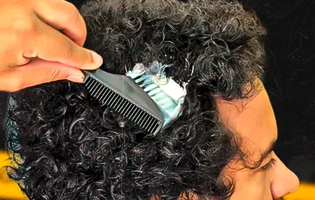 Cabelo cacheado recebendo o produto com pente
