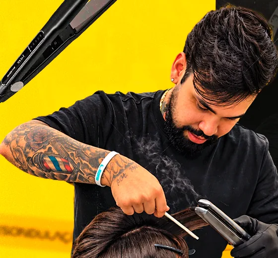Barbeiro finalizando o cabelo do cliente com prancha